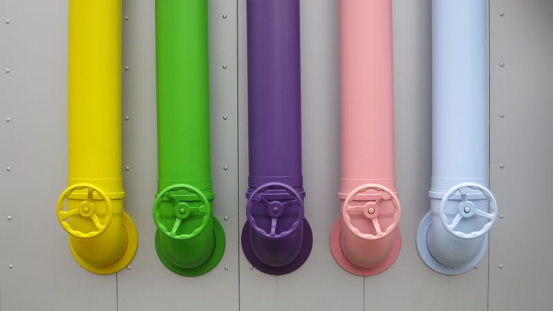 A photo of a row of coloured pipes - yellow, green, purple, pink and blue. From Legoland I think