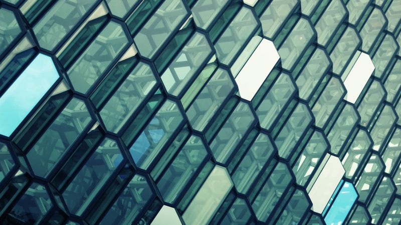 A photo of the glass front of the Harpa concert hall in Reykjavik. It has a crystalline, patterned structure