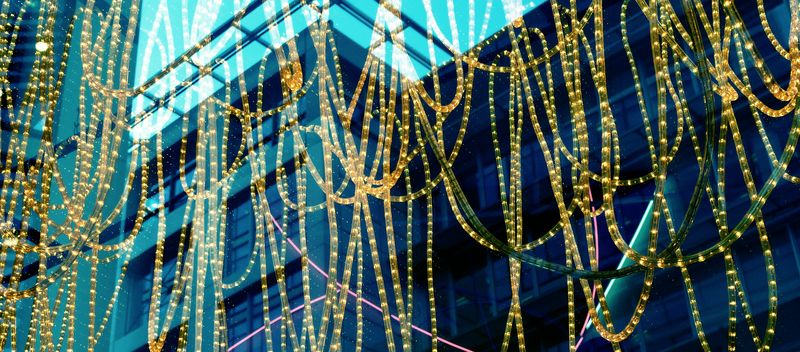 A photo of reflections in a London cafe window, behind which are looped cables of lighting